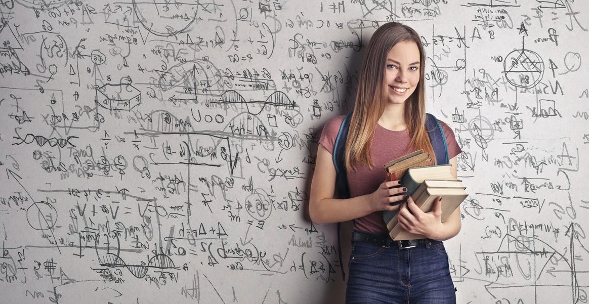 girl with books near whiteboard and formulas