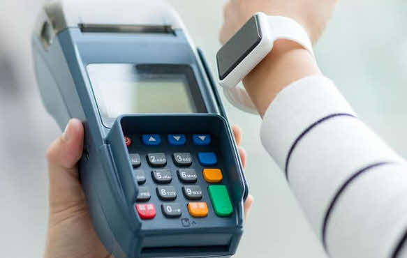 A smartwatch next to the POS terminal